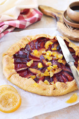 Red plums tart galette, candied citrus garnish