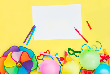 Bright yellow Festive background with empty blank and party tools and decoration - baloons, funny carnival masks, festive tinsel and garland with flags. Happy birthday design concept. Place for text.