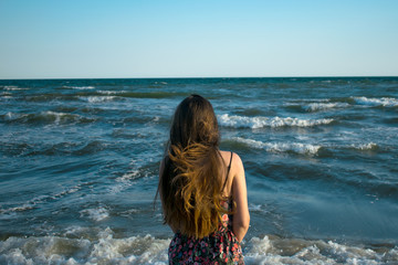 Fototapeta na wymiar Beautiful girl with long hair on the sea background. sensual, dreaming, free, traveling