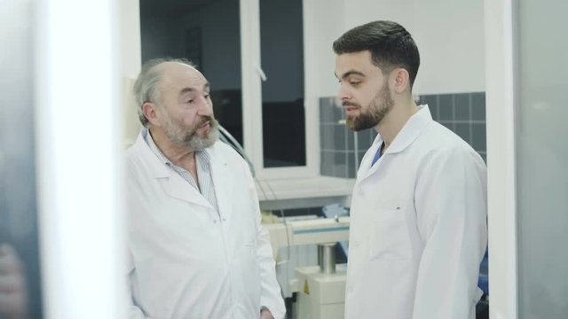 Doctors takling with co-worker on break in the rest room in hospital