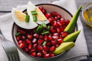 Home recipes: salad with avocado, eggs and pomegranate, close-up