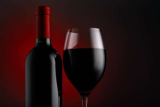  Bottle of red wine with a glass on a black background, horizontal close-up image