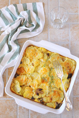 Vegetable potato and mushroom gratin with cheese in ceramic bakeware