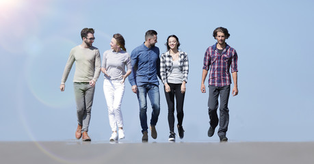 Obraz premium team of young people walking along the road.outdoors