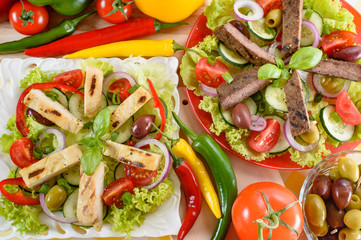 Chicken and beef salad on the plate. Grilled chicken and beef meat with tasty selection of vegetables. Food background.