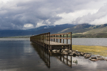 muelle de lago en el Mollar Tucuman Argentina . se observa su reflejo en el agua en una tarde de dia nublado