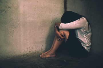 Woman sitting strain ,unhappy In the corner of the room, domestic violence, abuse and people...