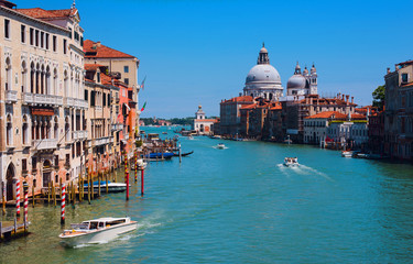 Fototapeta na wymiar Beautiful panoramic view over the famous Grand canal in Venice, surrounded by old and romantic architecture illuminated by sun, in Italy. Natural colors