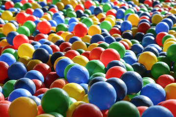 Fototapeta na wymiar Background texture of multi-colored plastic balls on the playground.
