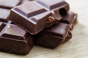 split bar of dark chocolate on wooden table