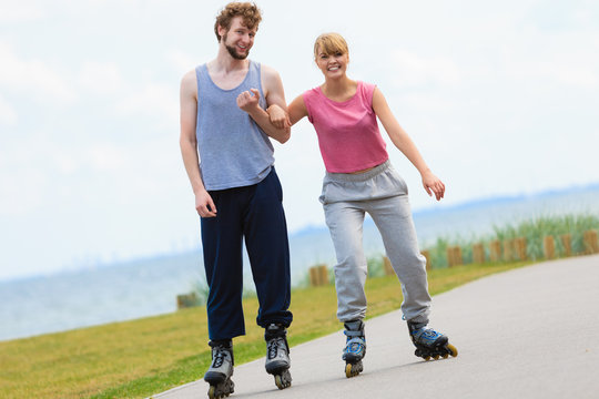 Man encourage woman to do rollerblading