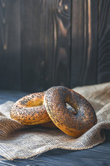 Fresh bagel with poppy seed on sackcloth. Russian traditional bakery product. or bakery pastry banner, ad, poster.