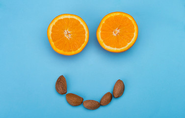 Fototapeta premium Healthy smiling face with oranges and almonds