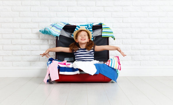 concept travel. happy funny girl child with suitcase