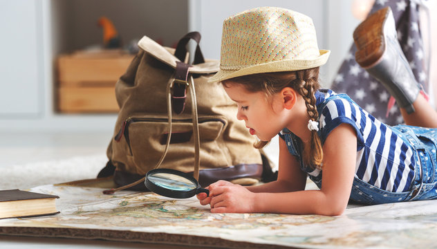 funny child girl tourist with world map, backpack and magnifier.