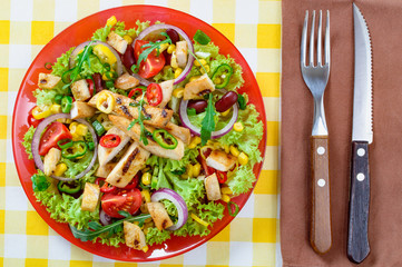 Mexican spicy chicken salad on the plate. Grilled chicken meat with tasty selection of vegetables.