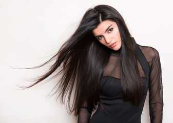 beautiful young woman with long black hair posing in black dress