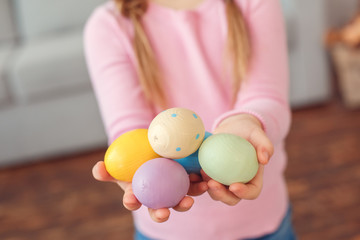 Little cute girl easter celebration at home concept standing holding eggs close-up