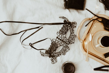 Sexy fashion concept. Set of black mask, glamorous stylish sexy lace lingerie, woman accessories on gold tray over bed