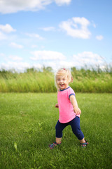 Cute Baby Toddler Girl Runing OUtside in the Grass on a Summer Day