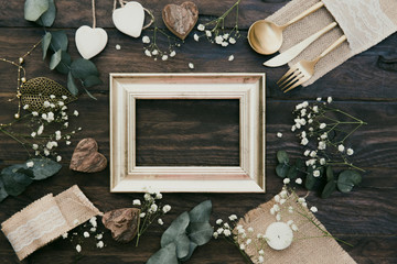 Details of a rustic wedding with gold frame over wooden background. Flat Lay, Top View, Copy Space