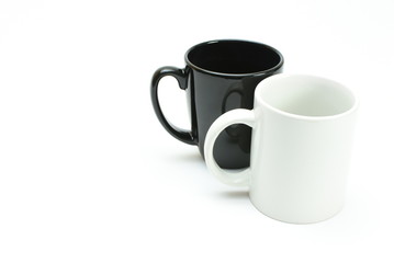 white coffee mug in front of black coffee mug, high key