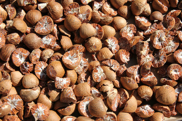 Brown and fresh nutmeg on table. Natural background.