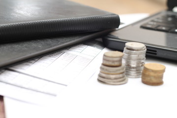 coins on the table, with laptops and financial reports.