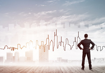 Motivation and inspiration concept with modern cityscape and businessman observing it