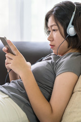 Asian woman listening music from mobile phone