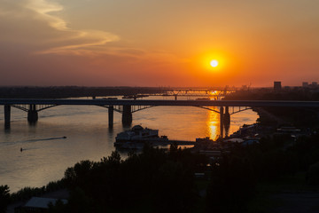 Fototapeta premium Beautiful sunset over the Octyabrsky bridge across river Ob in Novosibirsk