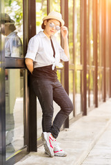 Women wearing hat standing in front of a glass building