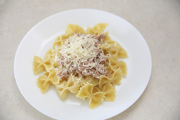 Farfalle pasta with tuna in a cozy kitchen
