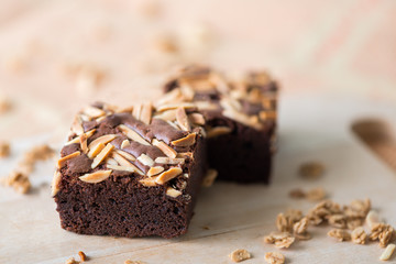 Close up sweet chocolate brownie with almond topping, selective focus