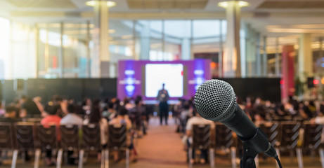 Microphone over the Abstract blurred photo of conference hall or seminar room with Speakers on the...