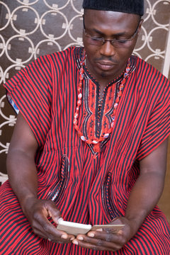 Man in traditional outfit checking phone