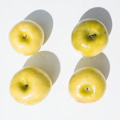 top view of four yellow Granny Smith apples
