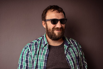 Obraz premium Handsome hipster bearded man with hat,sunglasses and shirt drink some strong liquor toast and celebrating.