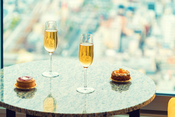 Gourmet pastries with white wine in a room high above the city