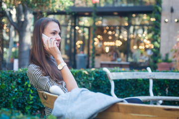 Smiling happy woman with mobile phone in the city