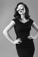 Young beautiful woman in black dress and sunglasses