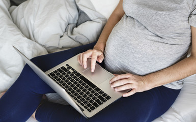 Naklejka premium Pregnant woman using computer laptop