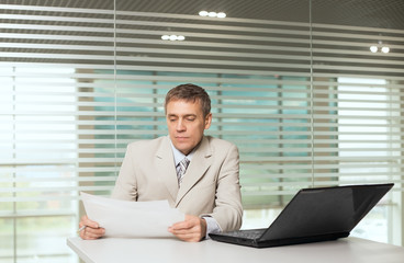 businesswoman sitting in office chair at the computer and work with documents