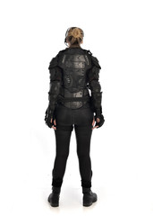 full length portrait of female  soldier wearing black  tactical armour  facing away from camera, isolated on white studio background.