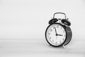 Black and white picture of Old Alarm Clock analog classic vintage style on paper retro background and copy space.