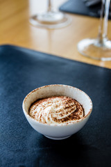 tiramisu on white plate, cocoa powder
