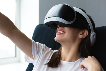 Woman wearing a VR headset and playing at home
