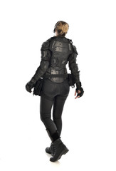 full length portrait of female  soldier wearing black  tactical armour  facing away from camera, isolated on white studio background.