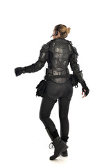 full length portrait of female  soldier wearing black  tactical armour  facing away from camera,...