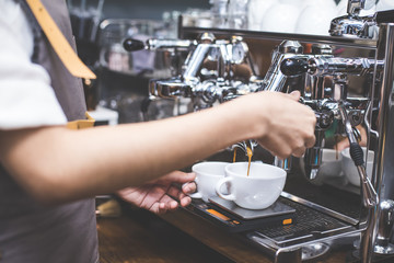 Hand of Barista making Coffee with coffee machine in the coffee shop. people with barista in cafe concept. Vintage tone.